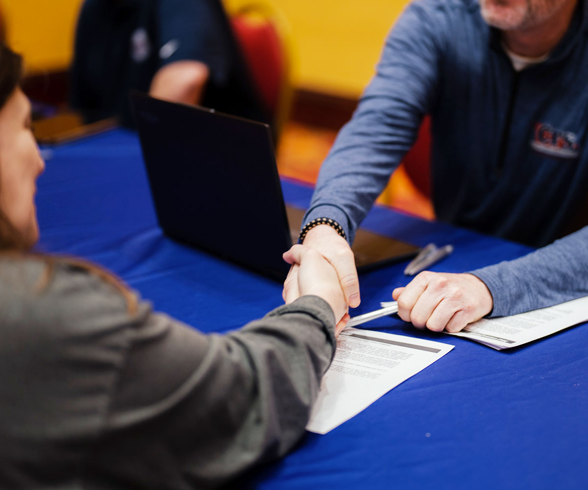 Two people shaking hands at the mattress fundraiser